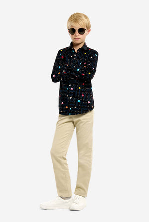 Person wearing a black patterned shirt, sunglasses and beige pants on a white background