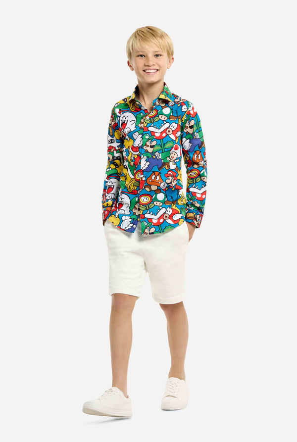 Image of teen wearing a Super Mario all over print shirt. Main color is blue, but there is also yellow, red and white. Kid also wearing shorts.
