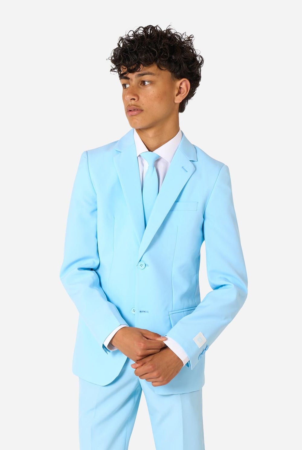 Teen wearing a light blue suit with a white shirt and tie on a light background.