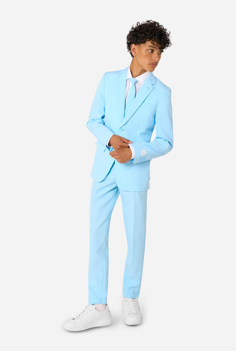 Teen wearing a light blue suit with a white shirt and tie on a light background.