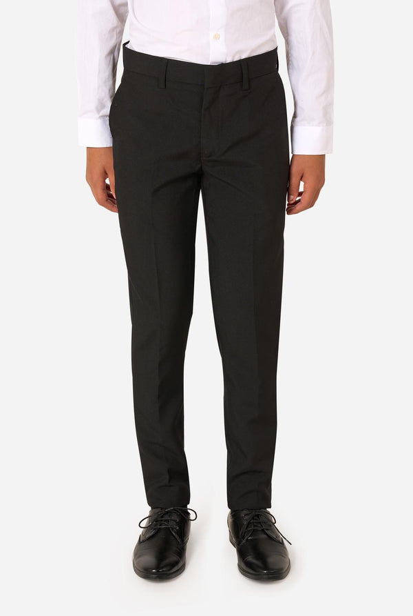 Teenager wearing a black suit and a white shirt on a light background. Pants close up.