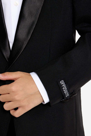 Close-up of a black tuxedo with 'Opposuits' branding on the cuff.