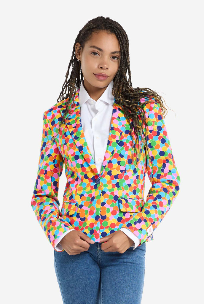 Woman wearing womens blazer with confetti print, holding bottom of the blazer with two hands