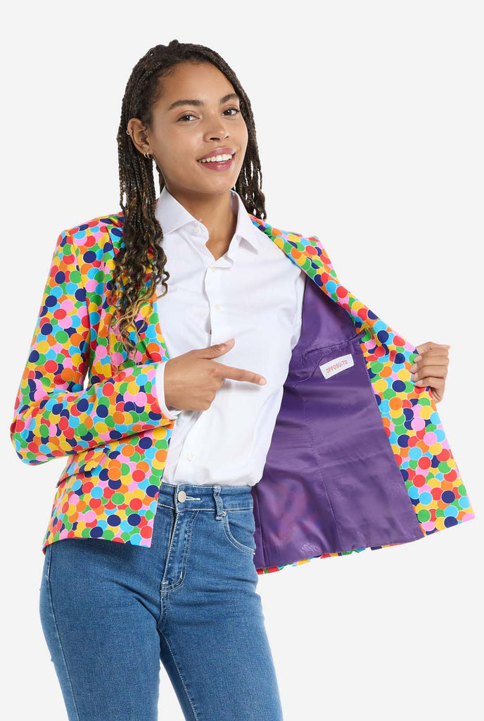 Woman wearing womens blazer with confetti print, opening one side of the blazer