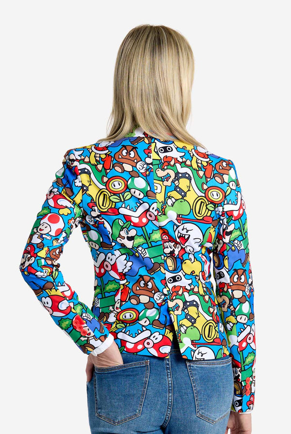Woman wearing all-over print Super Mario blazer with iconic Super Mario characters. The base is light blue, but there is also yellow, red and white. View from the back.