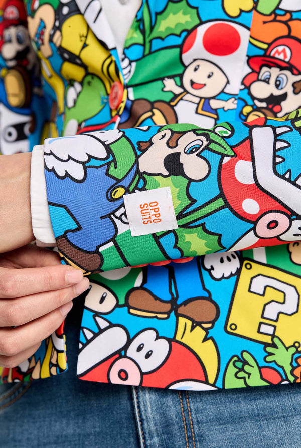 Woman wearing all-over print Super Mario blazer with iconic Super Mario characters. The base is light blue, but there is also yellow, red and white. Close up.