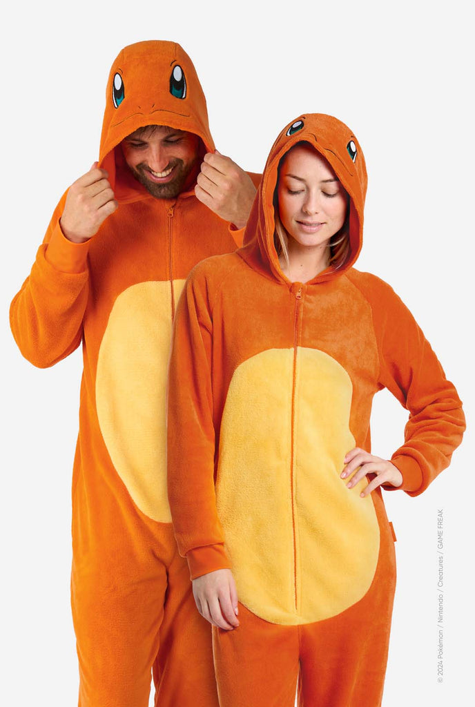 Man and woman are wearing an orange Pokemon Charmander Unisex onesie. Both looking at the floor. Perfect for Pokemon fans.