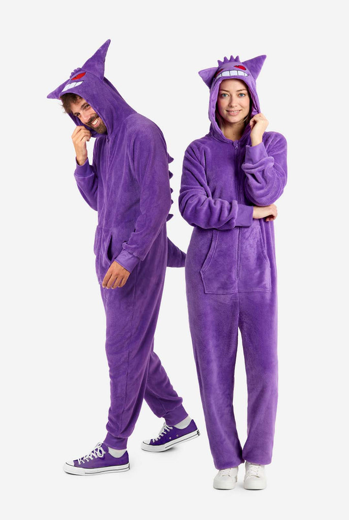 Man and woman wearing purple unisex adult onesie Pokeomon Gengar themed. Both looking at the camera.