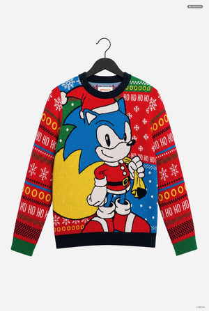 A festive crewneck sweater featuring Sonic the Hedgehog in a Christmas Santa outfit, hanging on a black hanger against a light gray background. The design includes a large blue and yellow graphic on the front, red patterned sleeves with 'HO HO HO' text, and a black ribbed collar, hem, and cuffs.