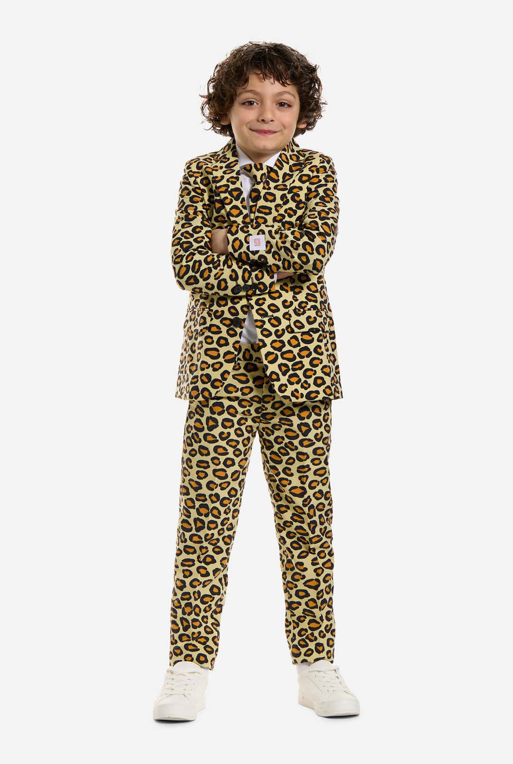 In this image, a kid is wearing a boys’ suit with all-over panther print and white shirt. The suit is beige with brown and black spotted panther print. Suits consists of jacket, pants and clip-on tie.