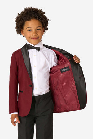Child in a formal outfit holding a matching jacket with 'Opposites' text.