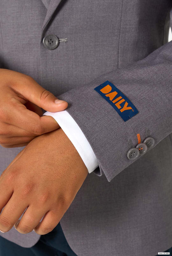 Close-up of the blazer sleeve featuring an orange “DAILY” label and grey buttons.