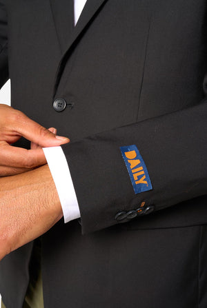 Close-up of a black suit jacket with a visible brand label on the sleeve.