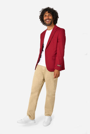 Man wearing a red blazer, white shirt, beige pants, and white shoes on a white background