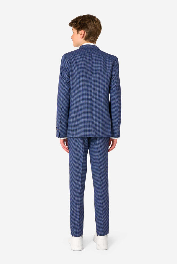 A teen boy wearing a navy and blue checkered suit with a white dress shirt. The suit has a modern fit with two buttons and flap pockets. He stands against a plain white background. View from the back