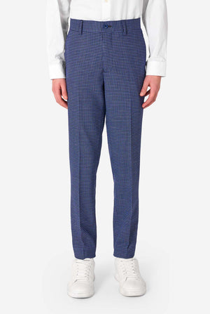 A teen boy wearing a navy and blue checkered suit with a white dress shirt. The suit has a modern fit with two buttons and flap pockets. He stands against a plain white background. Close up of the pants