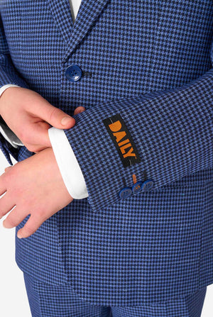 A teen boy wearing a navy and blue checkered suit with a white dress shirt. The suit has a modern fit with two buttons and flap pockets. He stands against a plain white background. Close up of the sleeves