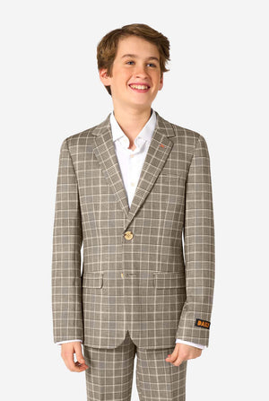 A teen boy wearing a tan checkered suit with a white dress shirt. The suit has a modern fit with two buttons and flap pockets. He stands against a plain white background. 