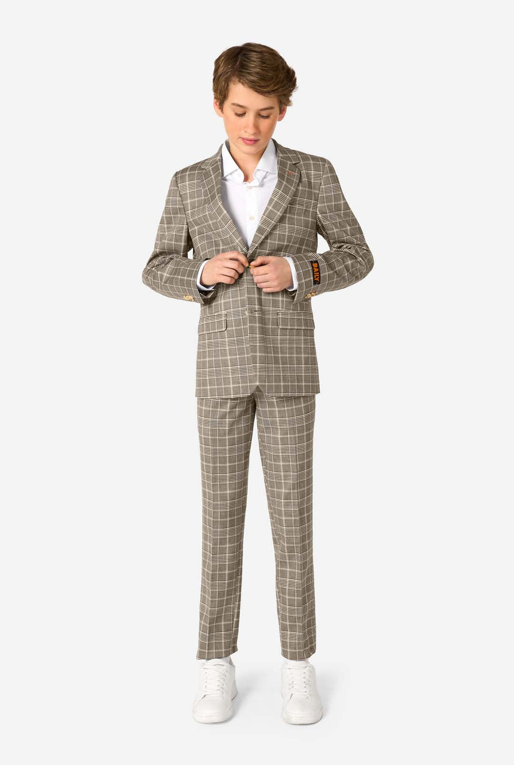 A teen boy wearing a tan checkered suit with a white dress shirt. The suit has a modern fit with two buttons and flap pockets. He stands against a plain white background. 