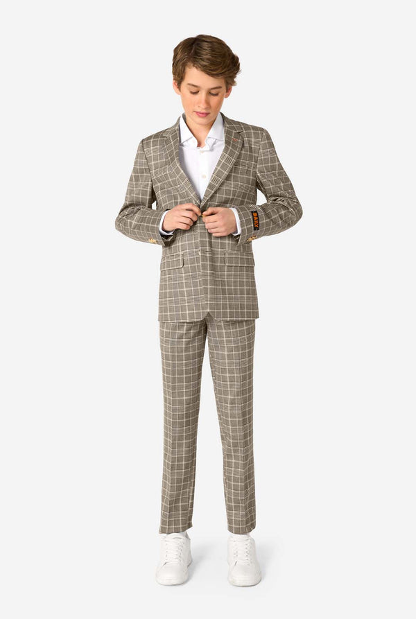 A teen boy wearing a tan checkered suit with a white dress shirt. The suit has a modern fit with two buttons and flap pockets. He stands against a plain white background. Full body image