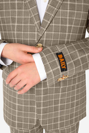 A teen boy wearing a tan checkered suit with a white dress shirt. The suit has a modern fit with two buttons and flap pockets. He stands against a plain white background. Close up of the sleeves