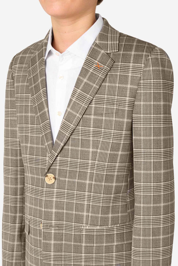 A teen boy wearing a tan checkered suit with a white dress shirt. The suit has a modern fit with two buttons and flap pockets. He stands against a plain white background. Close up of the chest