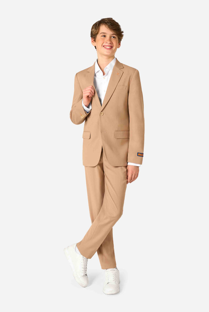 Teen boy wearing a stylish light brown/ beige suit with a white dress shirt, looking confidently in the camera. Perfect formal outfit for boys' special occasions, weddings, and parties. Full body image.