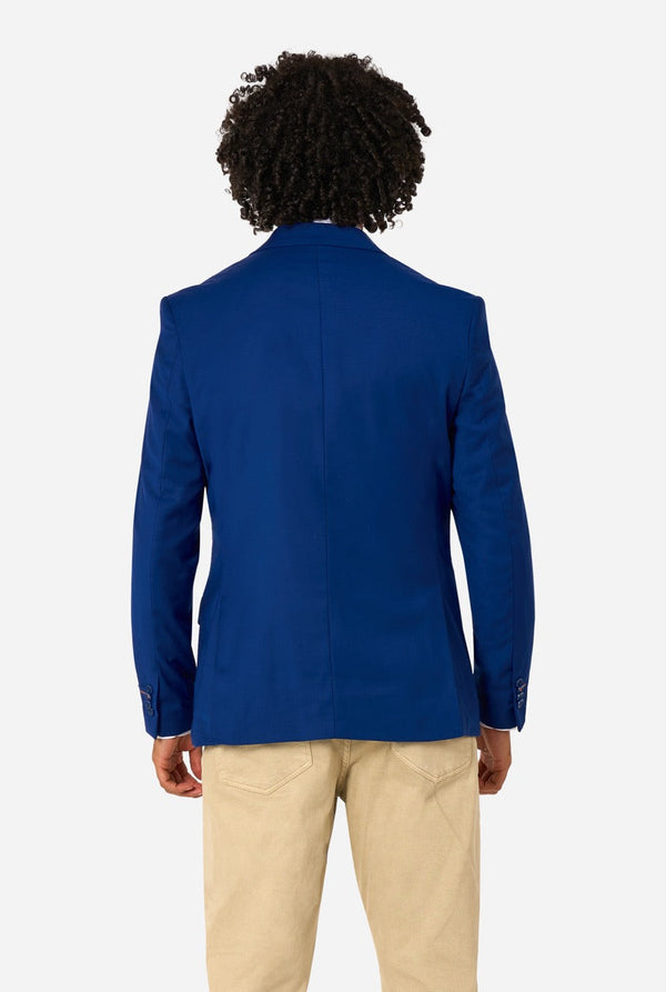 Person wearing a blue blazer and beige pants on a white background
