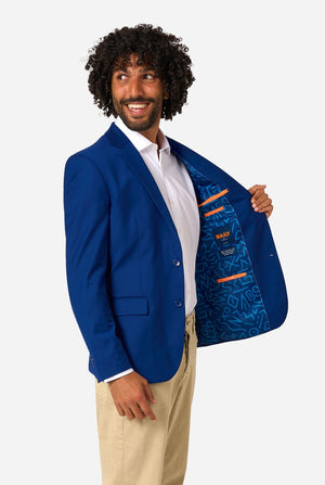 Man holding a blue jacket with a patterned lining on a white background