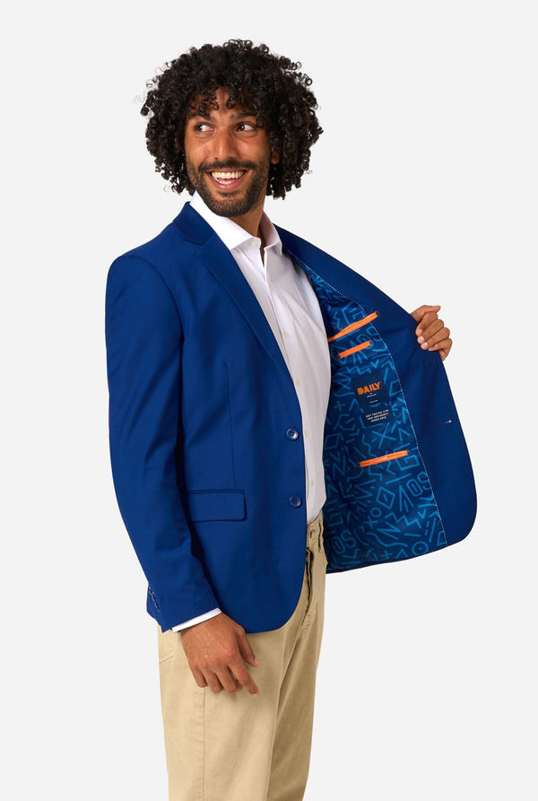Man holding a blue jacket with a patterned lining on a white background