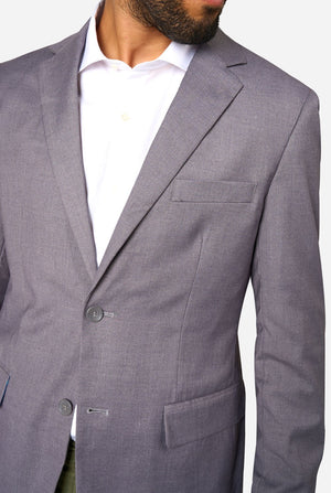 Gray suit jacket worn over a white shirt on a plain background