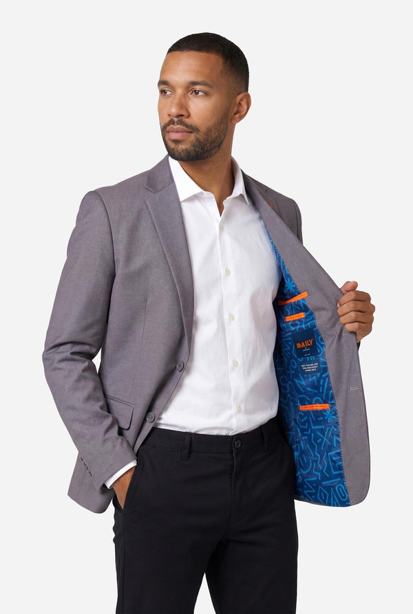 Image of a man wearing a grey blazer from OppoSuits Daily. also wearing a white shirt and black pants. Holding one side of the jacket open.