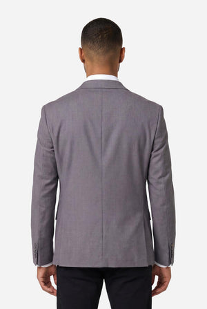 Image of a man wearing a grey blazer from OppoSuits Daily. also wearing a white shirt and black pants. View from the back.