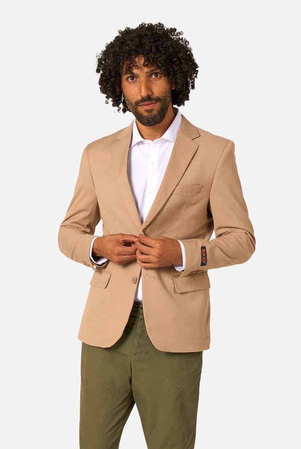Man wearing a beige blazer and green pants on a white background