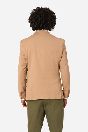 Person wearing a beige blazer and green pants on a white background