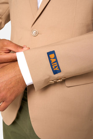 Beige suit jacket worn by a person on a white background, sleeve close up. 