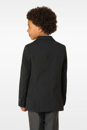 Back view of a boy wearing a plain black blazer and grey trousers, facing slightly sideways.