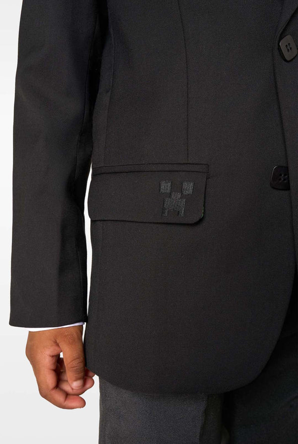 Close-up of the blazer pocket flap featuring a small black embroidered pixel-style icon.