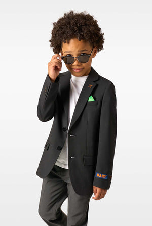 A boy wearing sunglasses, a white shirt, and a black blazer with a green pocket square, posing confidently.