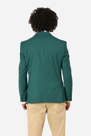 Person wearing a green blazer and beige pants on a white background