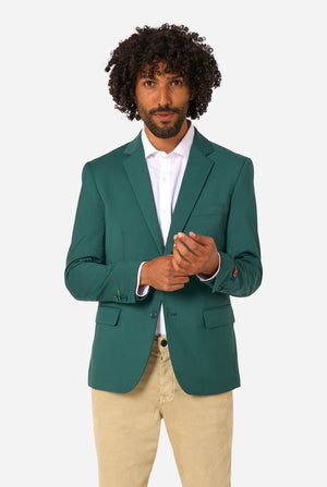 Man wearing a green blazer over a white shirt with beige pants on a white background