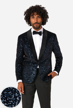 Man wearing a navy sequin tuxedo with a white shirt and bow tie on a light gray background.