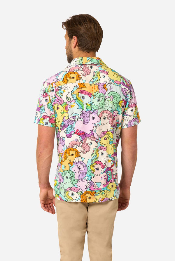 Man wearing a colorful Hawaiian shirt with My Little Pony character pattern on a light background. View from the back.