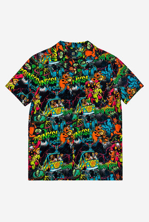 Packshot of the front side of a short-sleeve Hawaiian shirt with a vibrant, colorful, graphic Scooby-Doo print on a black background, against a plain light gray background.