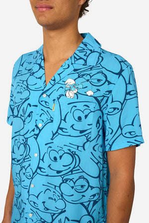 Person wearing a blue 'The Smurfs' themed shirt on a light background. Chest close-up.