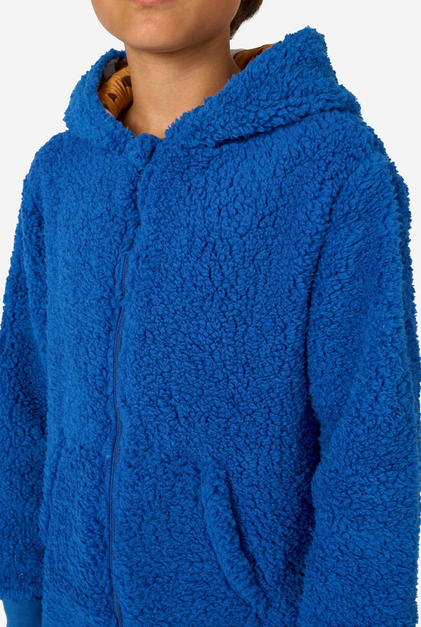 A kid is wearing a blue sesame street onesie resembling Cookie Monster. Close up.