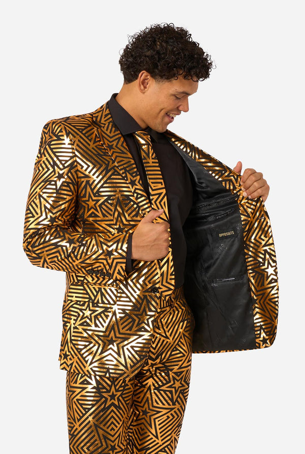 Men wearing golden suit with star print, holding one side of the jacket open.