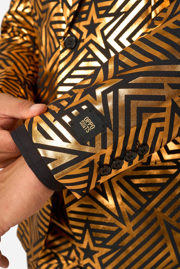 Gold and black patterned jacket with a brand label being held