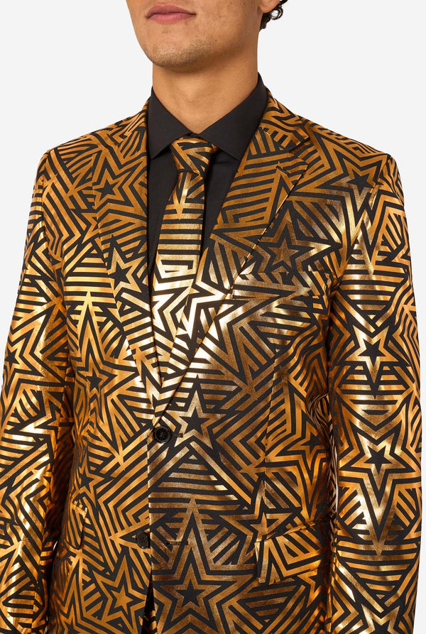 Man wearing a gold and black star-patterned suit jacket on a white background