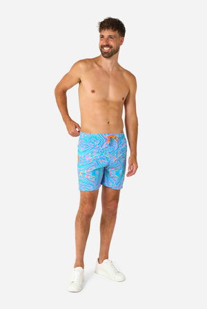 Man wearing a men's vibrant holographic swim shorts with a mesmerizing blue, pink, and purple swirl design. Eye-catching and stylish swimwear for summer fun. Full body image.